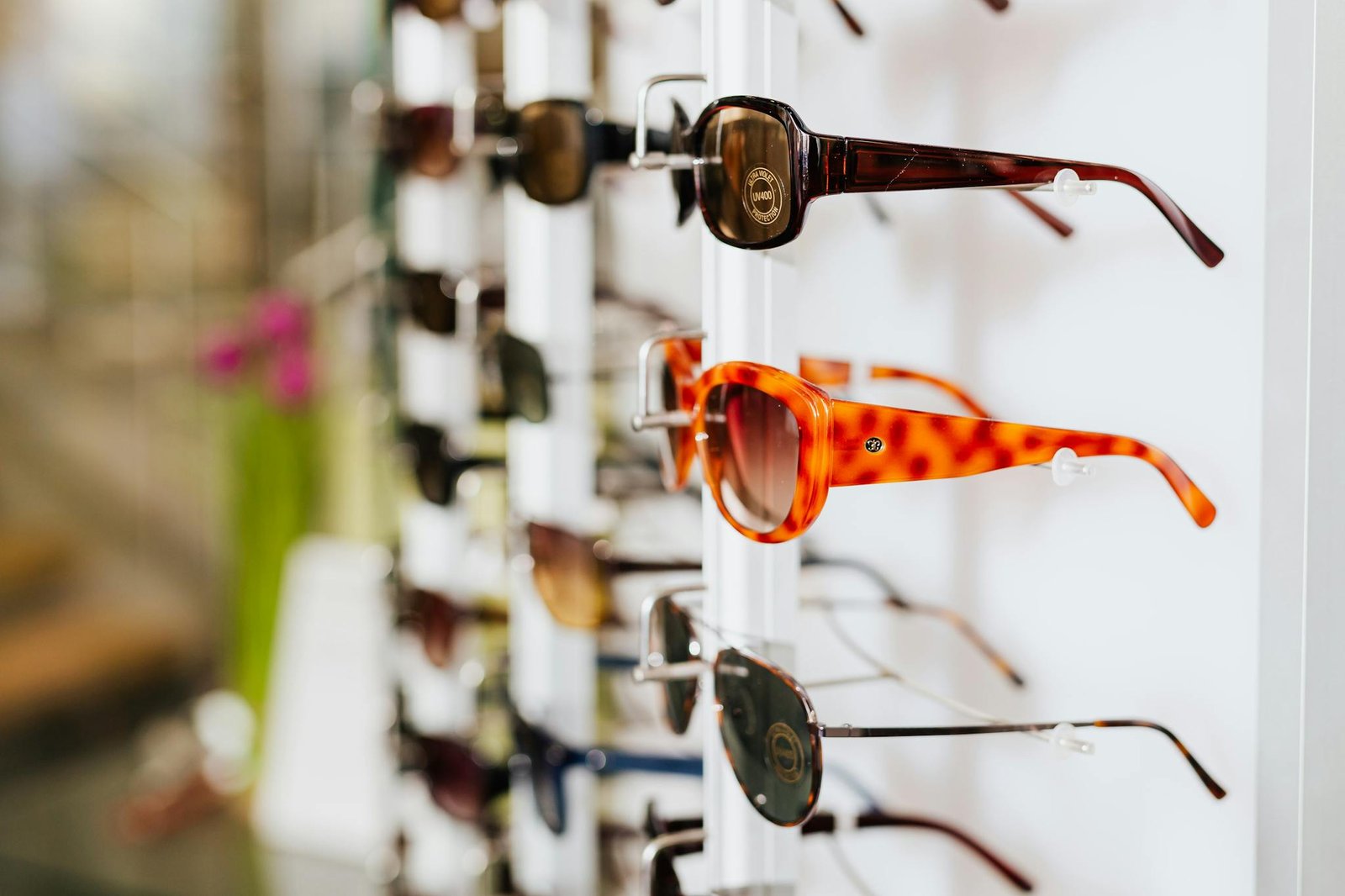 A vibrant assortment of fashionable sunglasses displayed on a store rack, ready for a trendy sale.